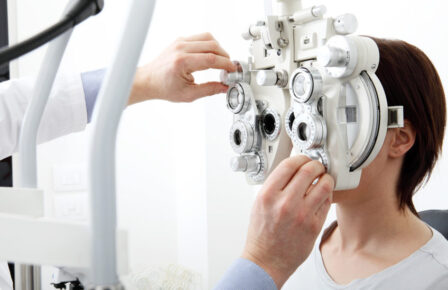 woman doing eyesight measurement with optical phoropter